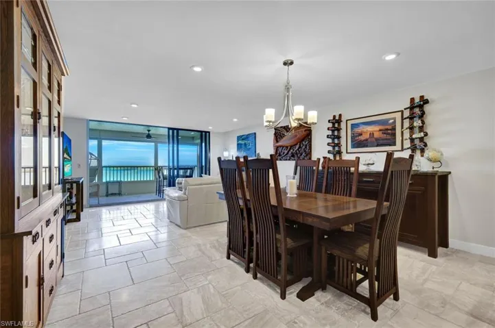 Dining room with suspended lighting, floor to ceiling windows, and a ceiling fan