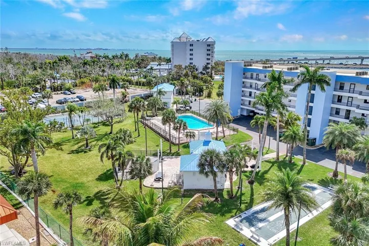 Drone / aerial view of a nearby body of water and apartment complex / building