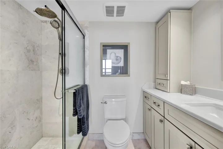 Full bath with a shower stall and vanity