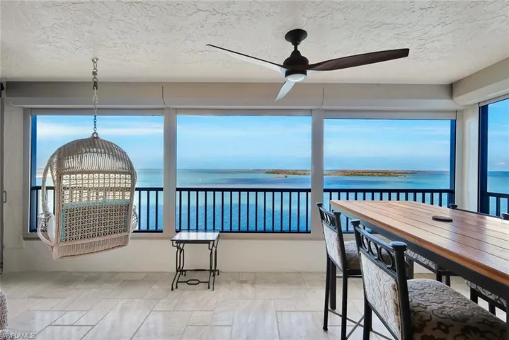 Sunroom / solarium with a water view and a textured ceiling