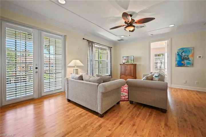 Living room featuring crown molding, ceiling fan, light wood-type flooring, and recessed lighting