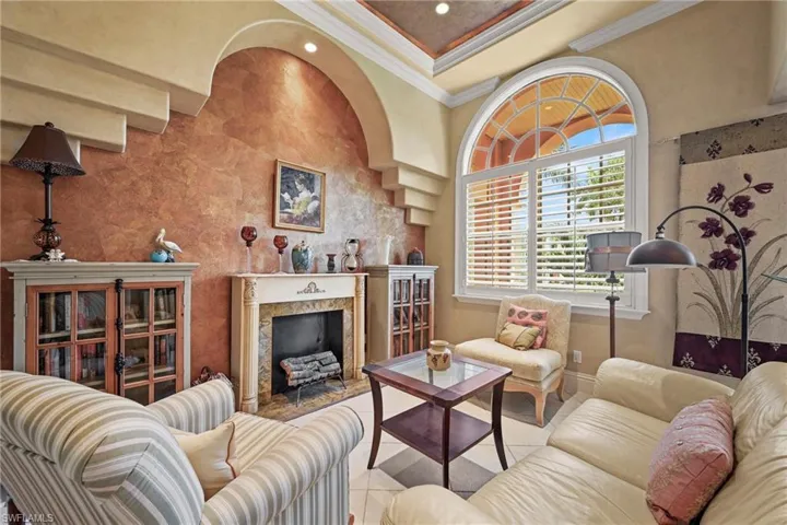Living room featuring a fireplace, ornamental molding, and recessed lighting