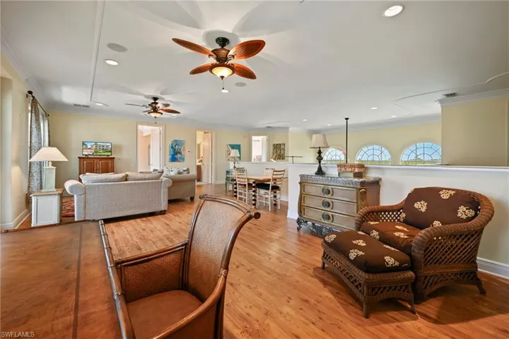Living area with recessed lighting, crown molding, a ceiling fan, and light wood finished floors