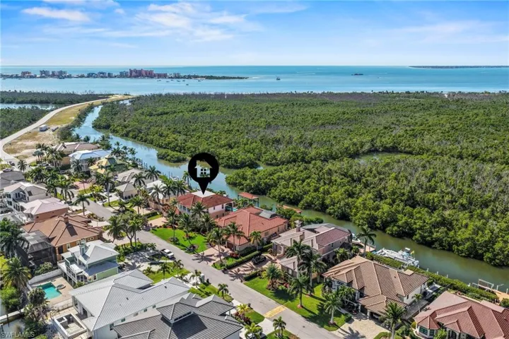 Aerial perspective of suburban area featuring a nearby body of water