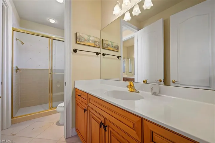 Full bathroom with vanity, a shower stall, and light tile patterned floors