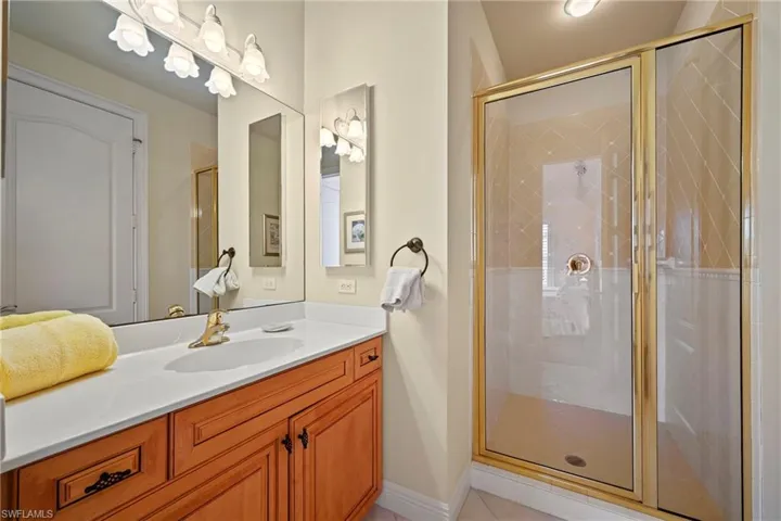 Full bathroom with a stall shower, vanity, and light tile patterned floors