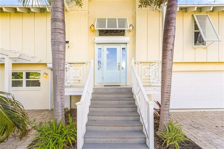 Entry to the home with roll-down hurricane shutters for the front door and the downstairs door to the left.