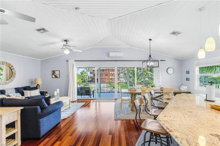 The open floor plan great room, kitchen, and dining room boast a wood ceiling, solid mahogany floors and views of Charlotte Harbor across the street.
