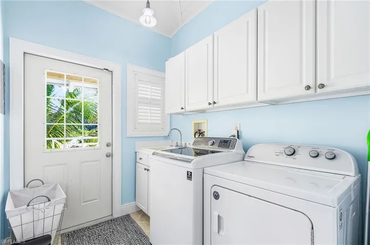Upstairs Laundry with a door leading outside, down the staircase to the pool.