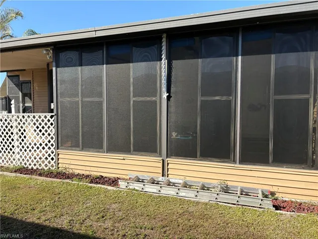 View of home's exterior with a yard and a sunroom