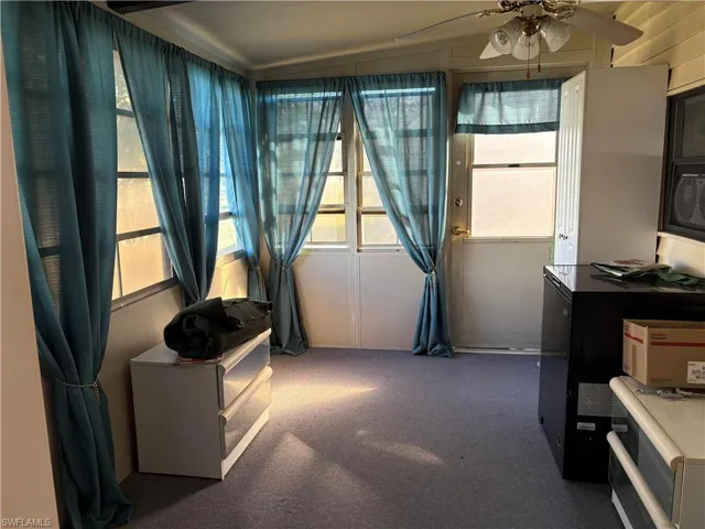 Sunroom / solarium with a wealth of natural light and ceiling fan