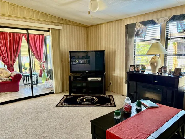 Carpeted living room featuring lofted ceiling