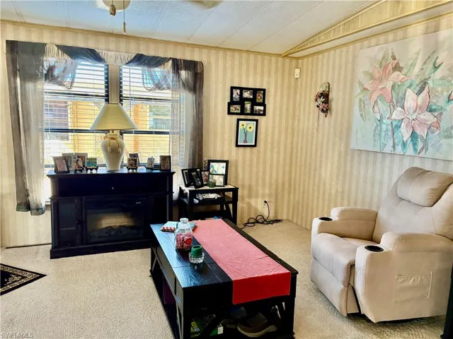 Carpeted living room featuring vaulted ceiling