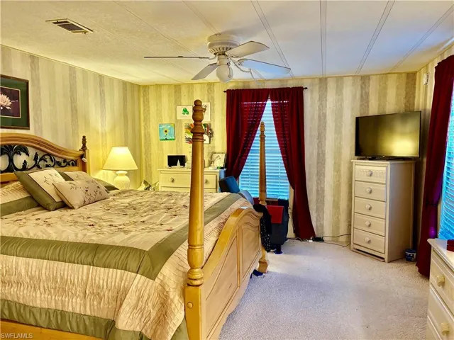 Carpeted bedroom featuring ceiling fan