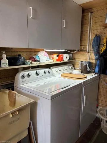 Laundry room featuring cabinets and washing machine and clothes dryer