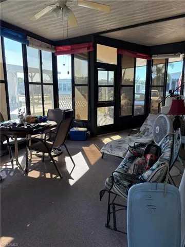 Sunroom / solarium with a wealth of natural light and ceiling fan
