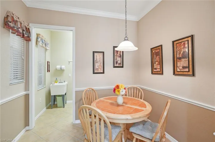 Dining area featuring baseboards, light tile patterned floors, and crown molding