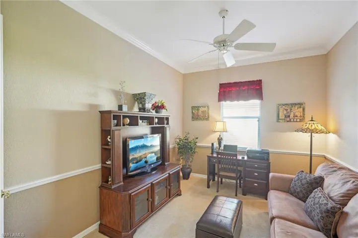 Living area with baseboards, light carpet, a ceiling fan, and ornamental molding