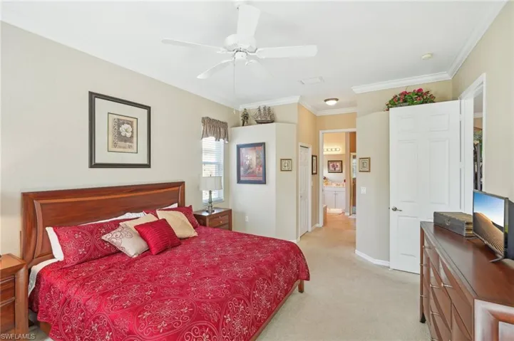 Bedroom featuring light colored carpet, ceiling fan, crown molding, and baseboards