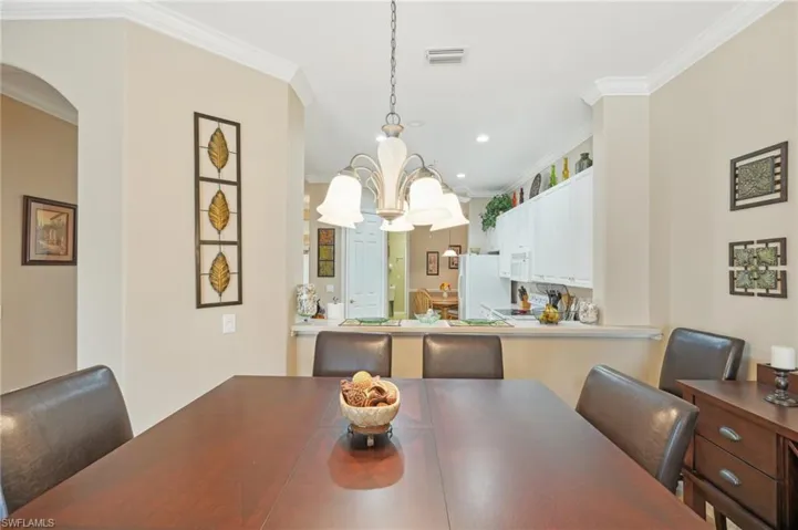 Dining area with visible vents, recessed lighting, crown molding, and arched walkways