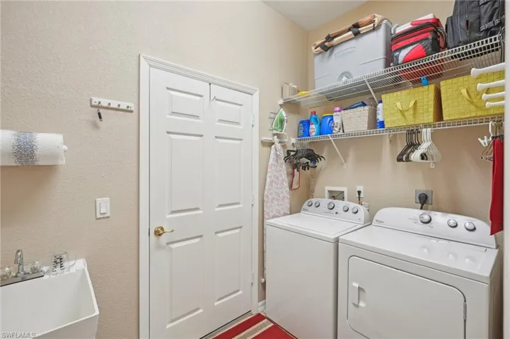 Clothes washing area with washer and clothes dryer, a sink, and laundry area