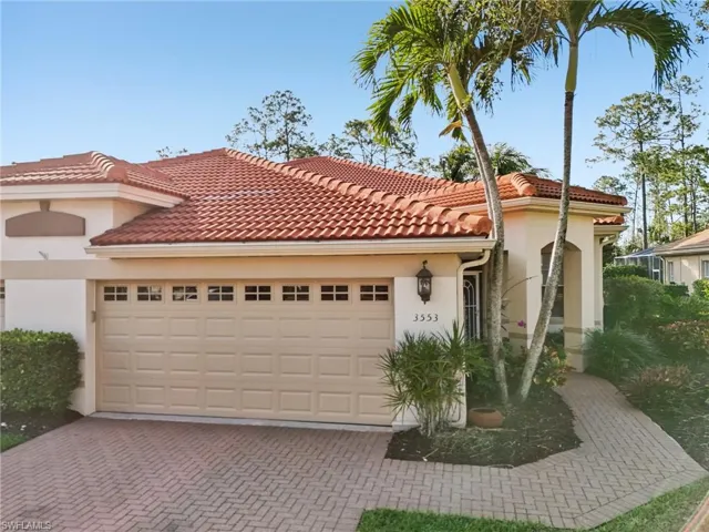 Mediterranean / spanish home with a tiled roof, stucco siding, an attached garage, and decorative driveway