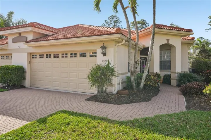 Mediterranean / spanish home with a tiled roof, stucco siding, decorative driveway, and a garage