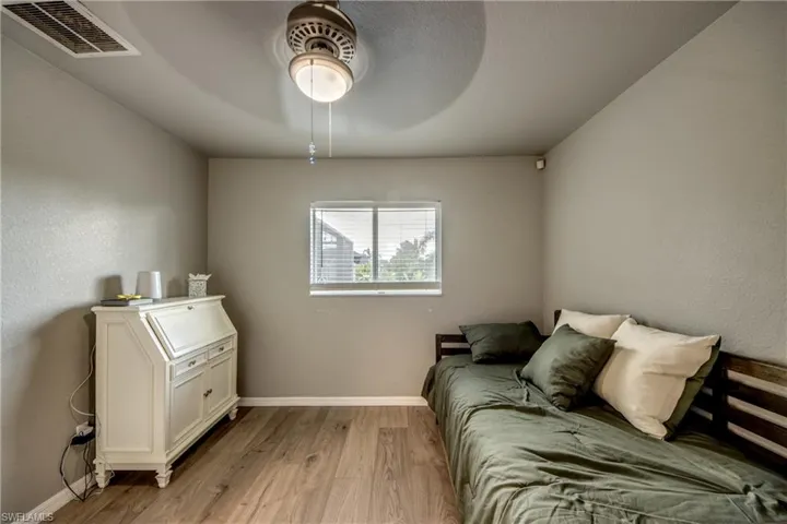 Living room with lofted ceiling, a ceiling fan, and light tile patterned flooring
