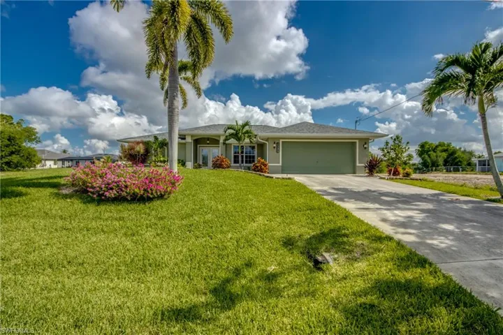 Ranch-style house featuring a garage, concrete driveway, stucco siding, and a front lawn