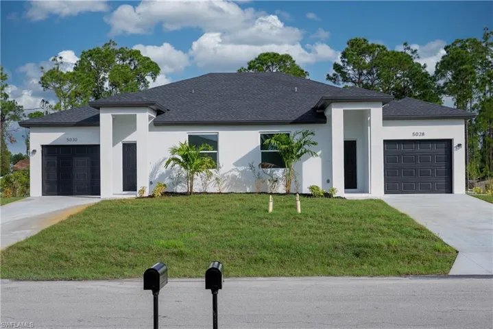 View of front of house featuring a garage and a front lawn