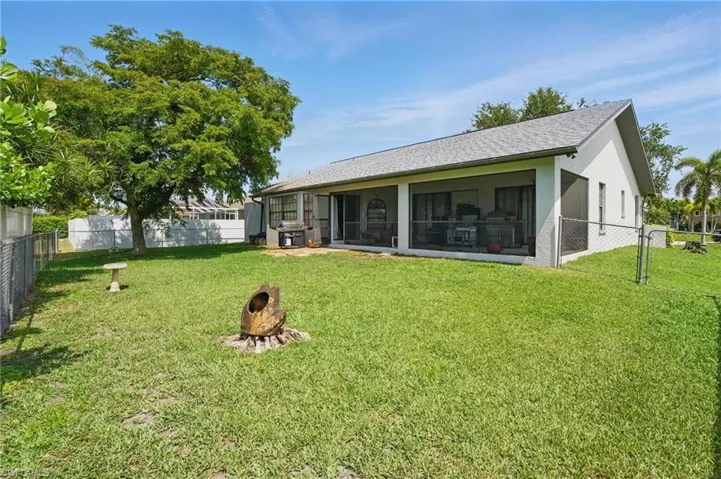 Back of house featuring a sunroom, stucco siding, and roof with shingles