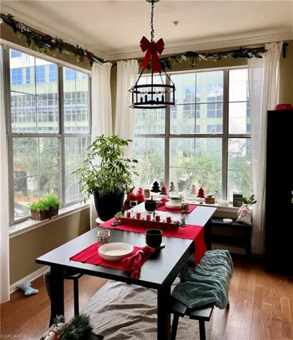 Dining room with wood-type flooring, a chandelier, and crown molding