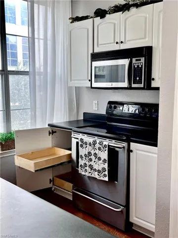 Kitchen featuring stainless steel appliances and white cabinets