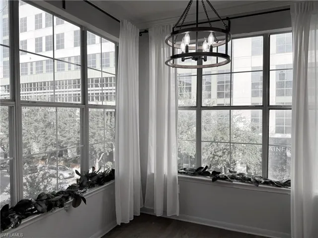 Unfurnished dining area with a chandelier and dark hardwood / wood-style flooring