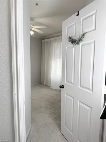 Corridor with light colored carpet and crown molding