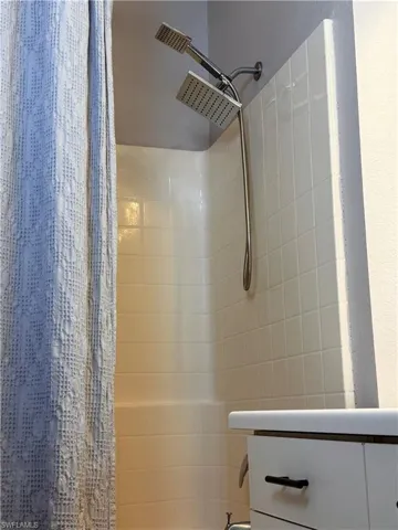 Bathroom with shower / bathtub combination with curtain