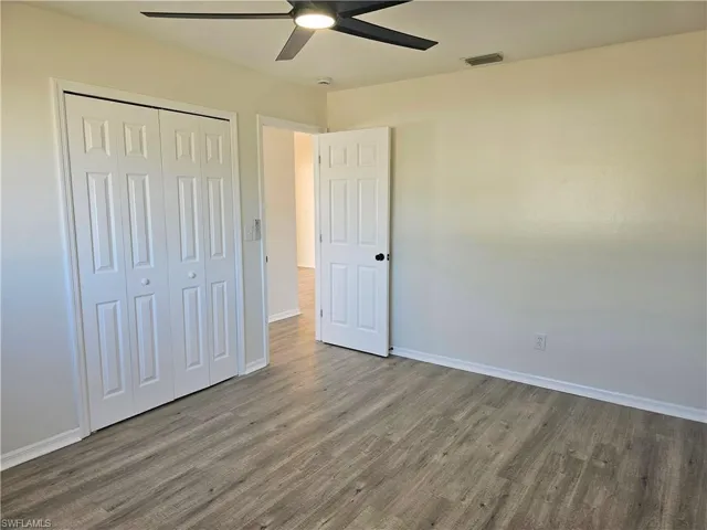 Unfurnished bedroom featuring wood finished floors, ceiling fan, and a closet