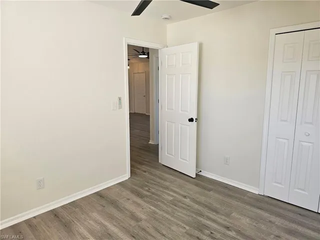 Unfurnished bedroom with wood finished floors, ceiling fan, and a closet