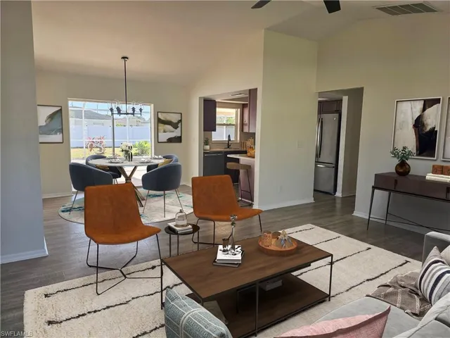 Living room featuring a chandelier, dark wood-style flooring, high vaulted ceiling, and ceiling fan