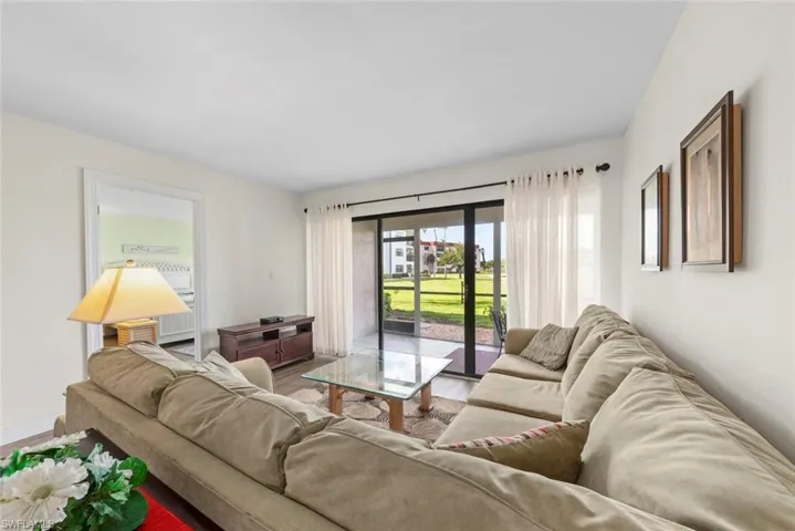 Living area featuring light wall tones, vinyl flooring, and a lanai