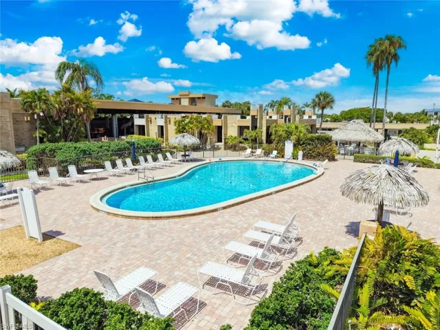 Outdoor community pool area featuring a freeform swimming pool surrounded by paver decking