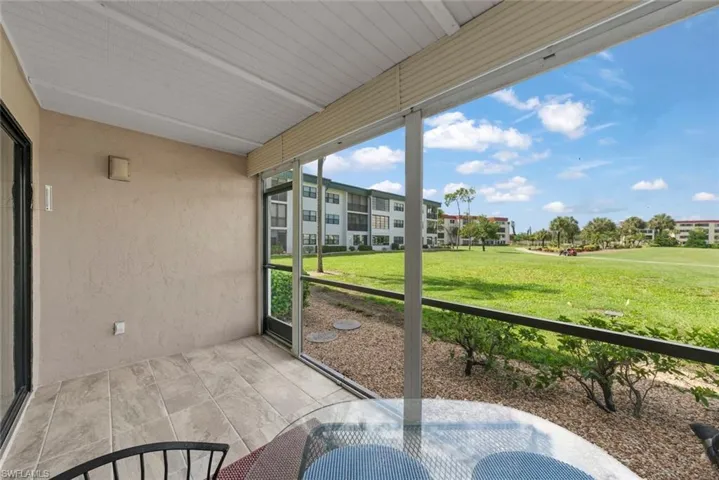 Screened lanai featuring large tile flooring and the golf course