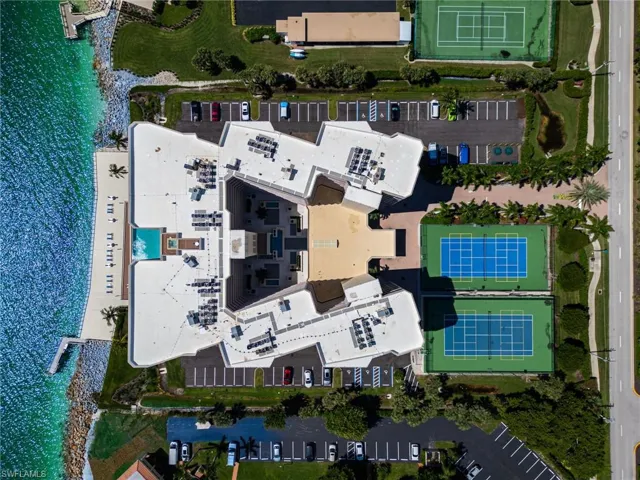 Bird's eye view of the prestigious Mirage Condominium- highlighting the Gulfside pool and tennis and pickleball activity courts that create this vibrant beachside community.