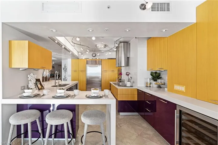 Kitchen featuring a kitchen bar, wine cooler, and Subzero refrigerator accompany the Faber range hoods, and Thermador cooktop