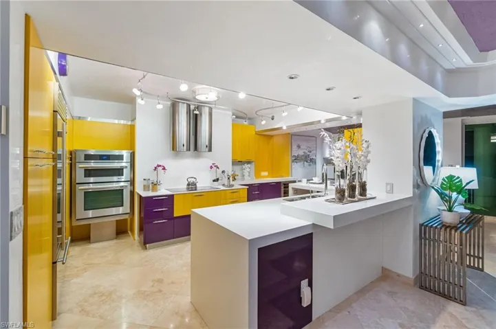 The expansive custom Kitchen boasts modern vibrant Italian cabinets, top appliance package with stainless steel finishes, 2 white quartz peninsulas and beautiful and functional modern contemporary track lighting.