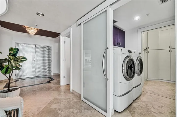 The spacious foyer entry leads past a bright, renovated laundry room and walk in sizable pantry and storage room.