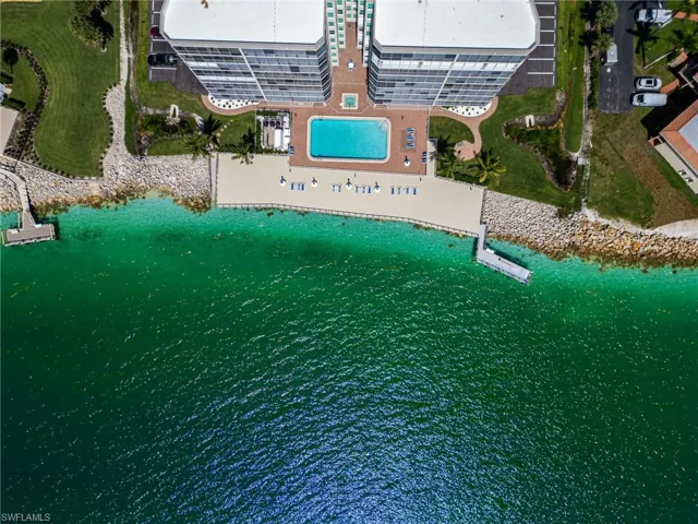 Stunning Gulf Waters greet the shoreline in front of the Mirage highlighting the community deck, dock, pool and hot tub.