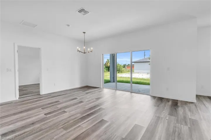 Empty room featuring a chandelier and light wood-style floors