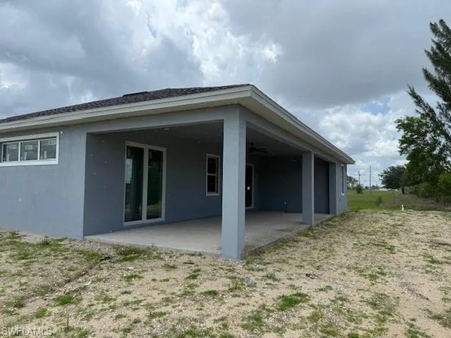 Rear view of house featuring a patio area, a ceiling fan, and stucco siding
