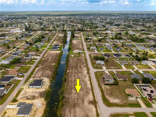 Aerial view of property's location with nearby suburban area and a nearby body of water